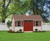 Deluxe Quaker 10′ x 16′ • Classic linen vinyl siding, clay trim, red doors and shutters, bark architectural shingles
